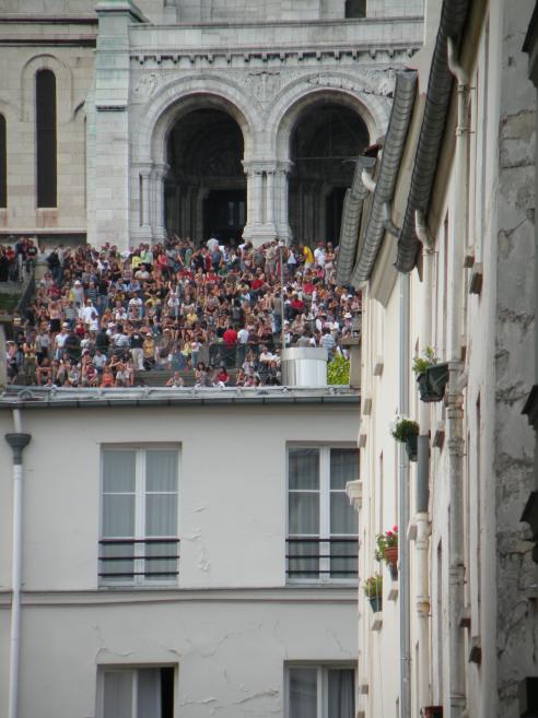   foule assise sur le toit d'un immeuble